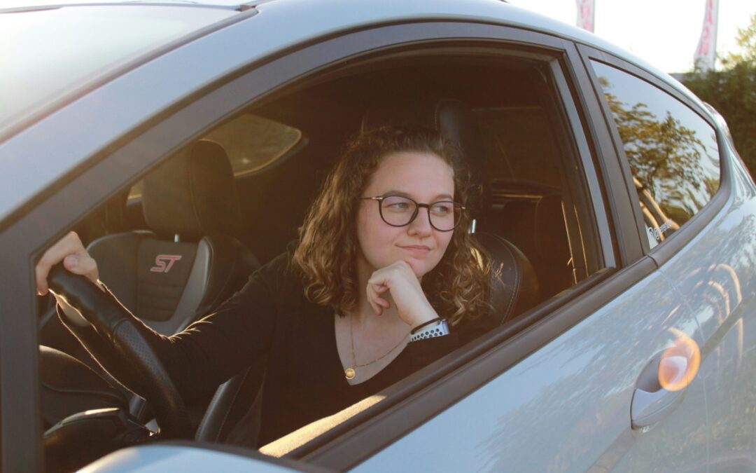 Young woman driver contemplating used car purchase, highlighting importance of pre-purchase inspections